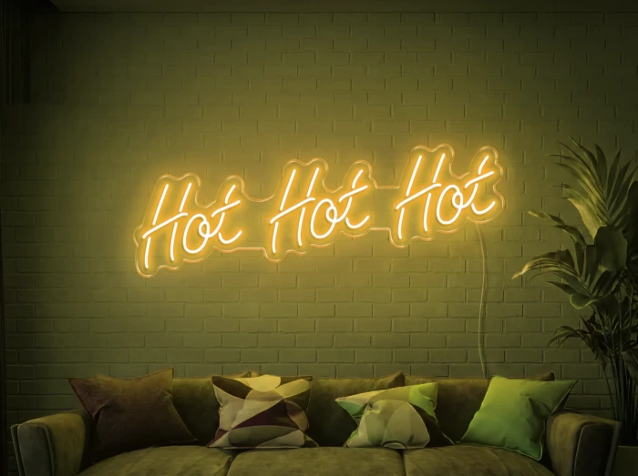 Neonskylt «Hot Hot Hot» i gul LED-neon, monterad på vägg