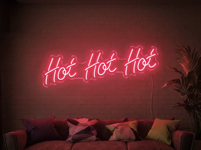 Neonskylt «Hot Hot Hot» i röd LED-neon, monterad på vägg