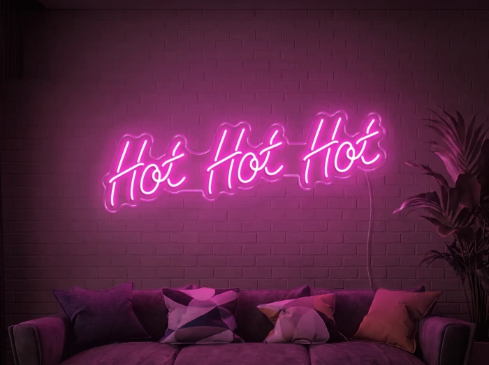Neonskylt «Hot Hot Hot» i rosa LED-neon, monterad på vägg