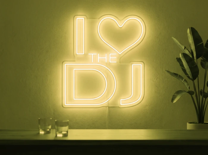 Neonskylt «I Love The DJ» i gul LED-neon, monterad på vägg