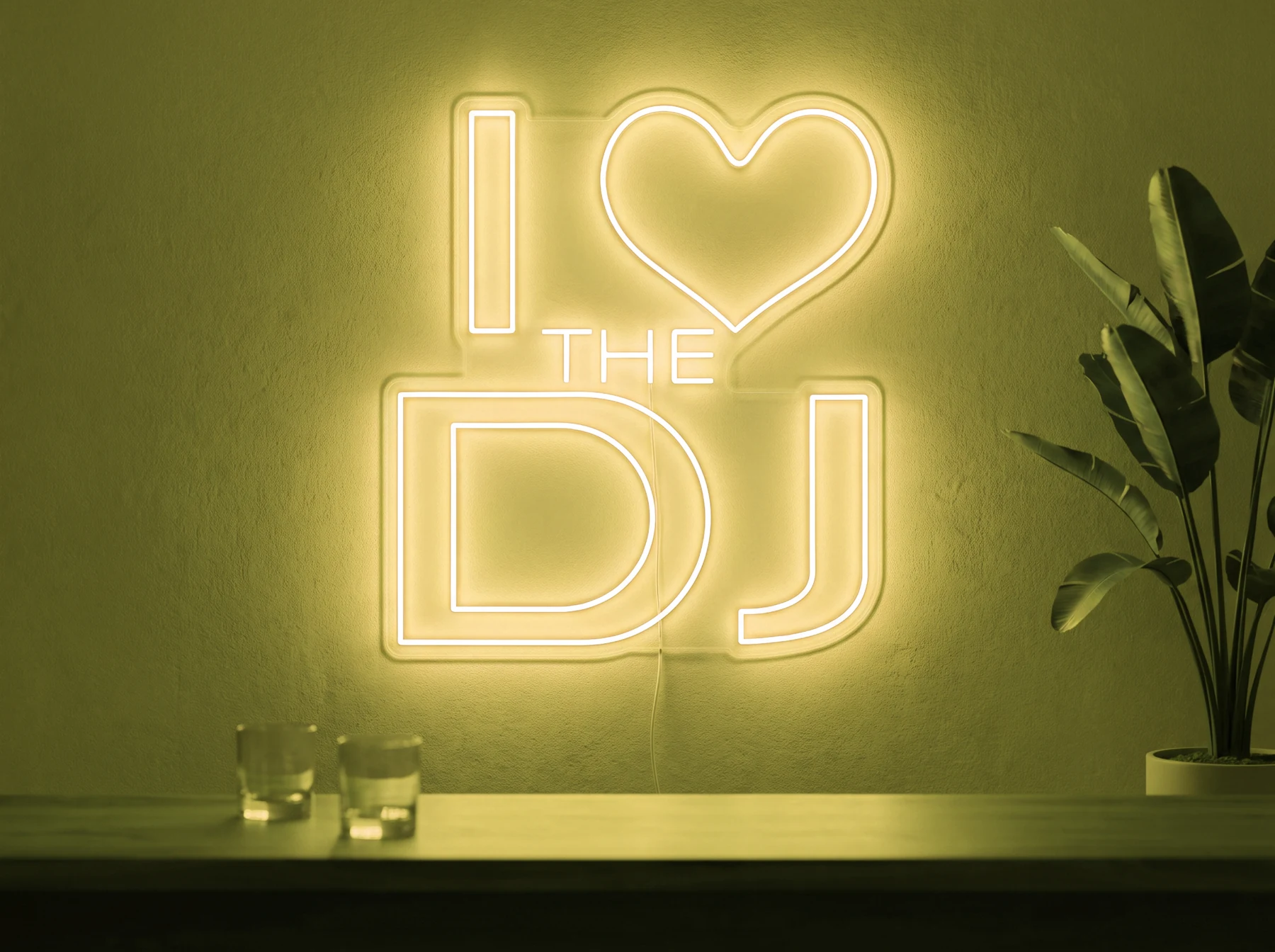 Neonskylt «I Love The DJ» i gul LED-neon, monterad på vägg
