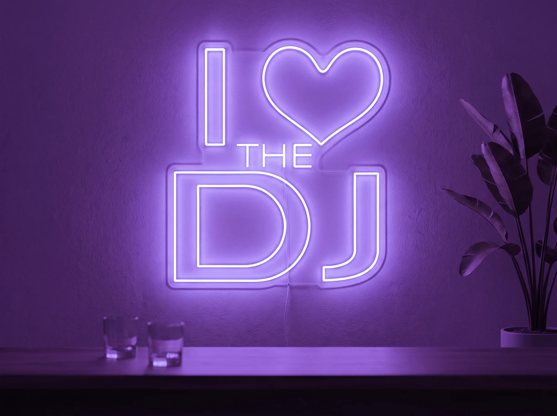 Neonskylt «I Love The DJ» i lila LED-neon, monterad på vägg