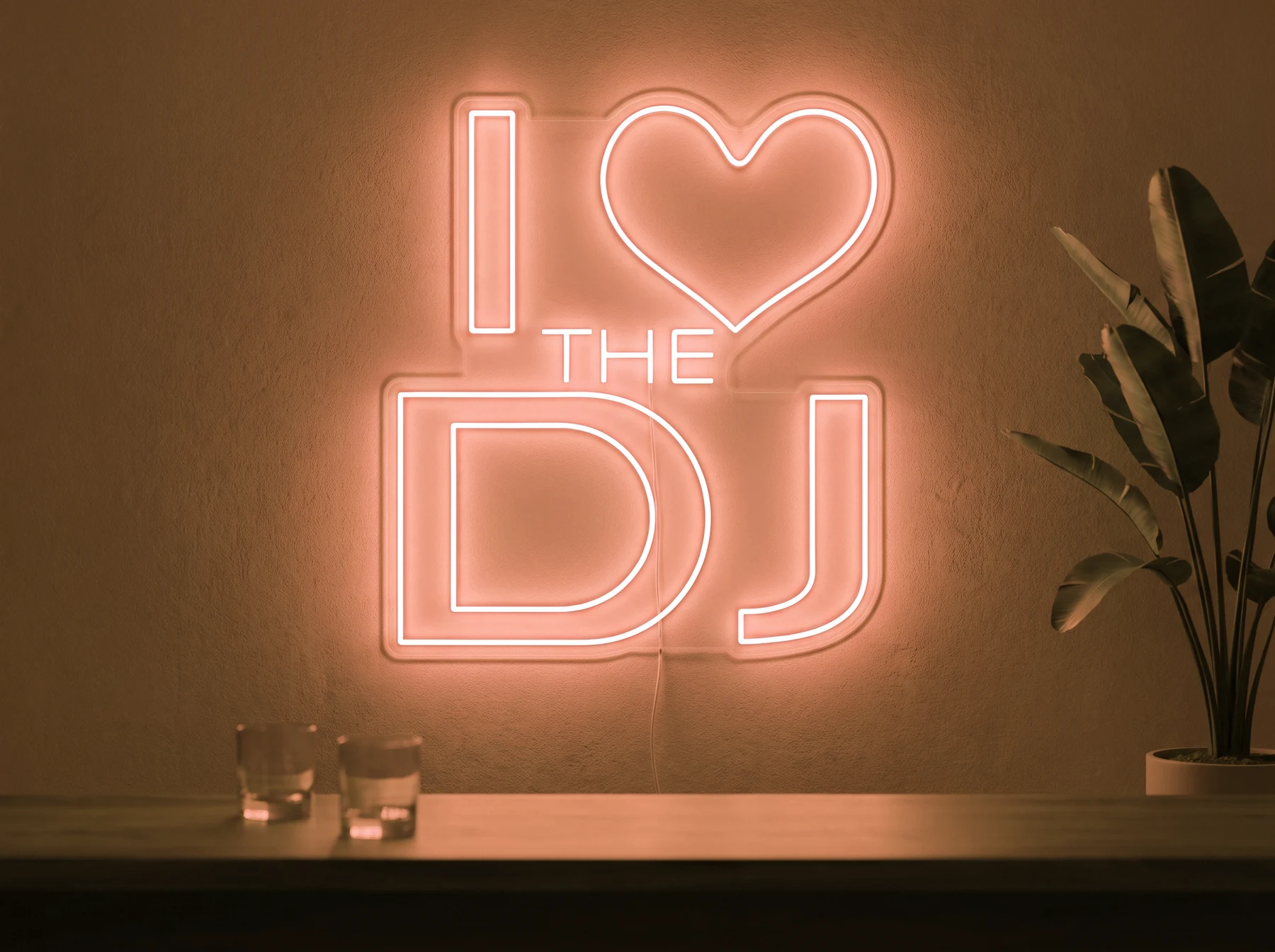 Neonskylt «I Love The DJ» i orange LED-neon, monterad på vägg