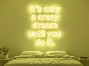 Neonskylt «It’s Only A Crazy Dream» i gul LED-neon, monterad på vägg