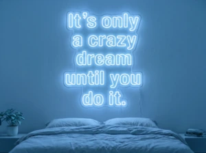 Neonskylt «It’s Only A Crazy Dream» i isblå LED-neon, monterad på vägg