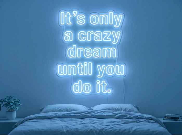 Neonskylt «It’s Only A Crazy Dream» i isblå LED-neon, monterad på vägg