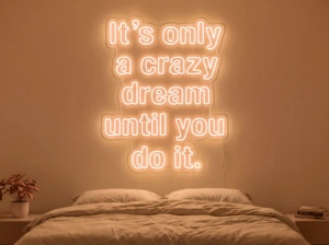 Neonskylt «It’s Only A Crazy Dream» i orange LED-neon, monterad på vägg