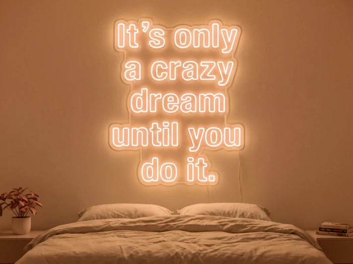 Neonskylt «It’s Only A Crazy Dream» i orange LED-neon, monterad på vägg