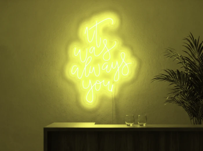 Neonskylt «It Was Always You, smal» i gul LED-neon, monterad på vägg