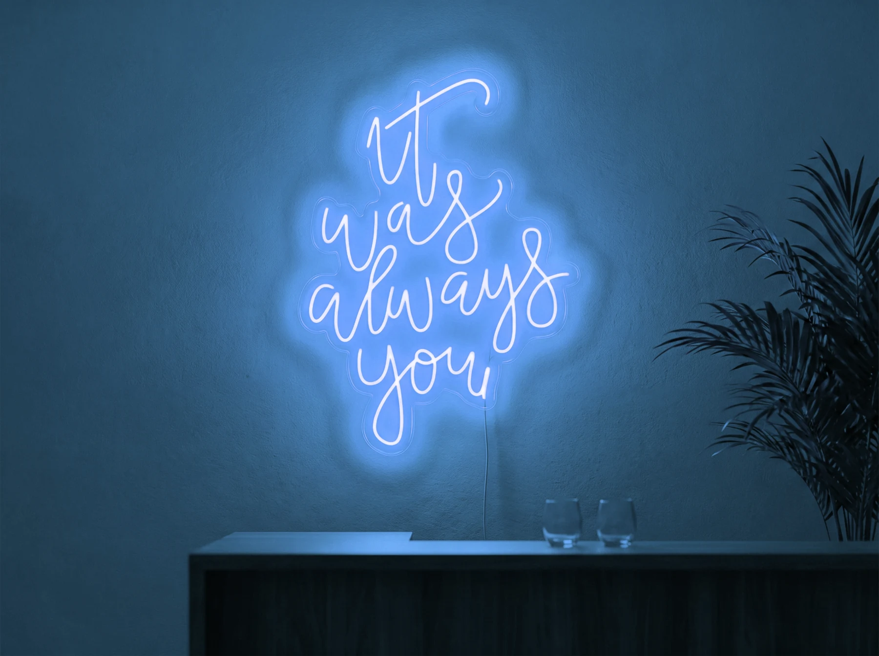 Neonskylt «It Was Always You, smal» i isblå LED-neon, monterad på vägg
