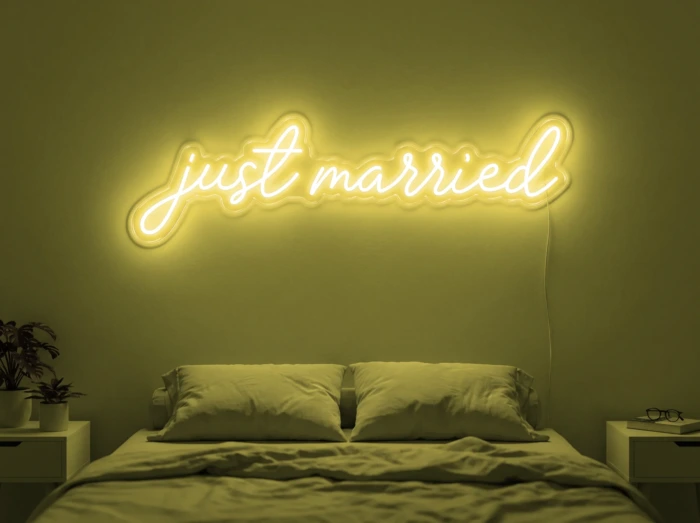 Neonskylt «Just Married» i gul LED-neon, monterad på vägg