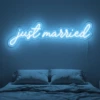 Neonskylt «Just Married» i isblå LED-neon, monterad på vägg