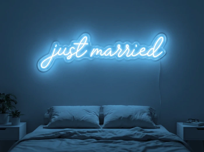 Neonskylt «Just Married» i isblå LED-neon, monterad på vägg