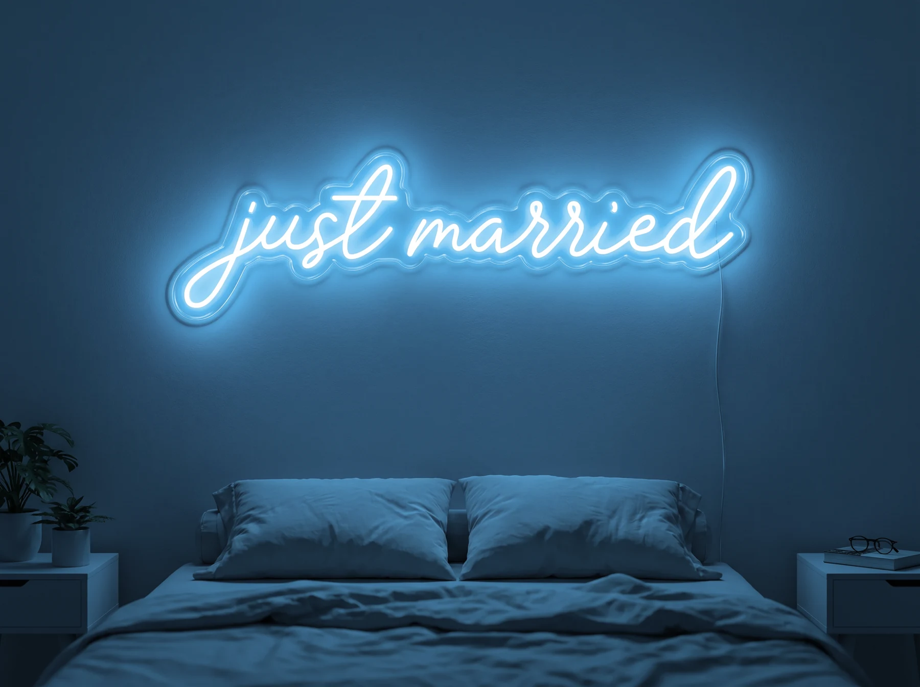 Neonskylt «Just Married» i isblå LED-neon, monterad på vägg