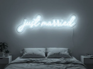 Neonskylt «Just Married» i iskall vit LED-neon, monterad på vägg