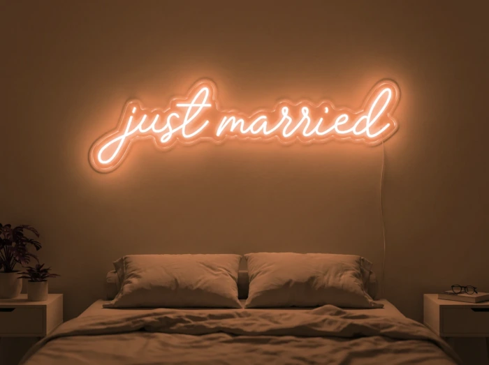 Neonskylt «Just Married» i orange LED-neon, monterad på vägg