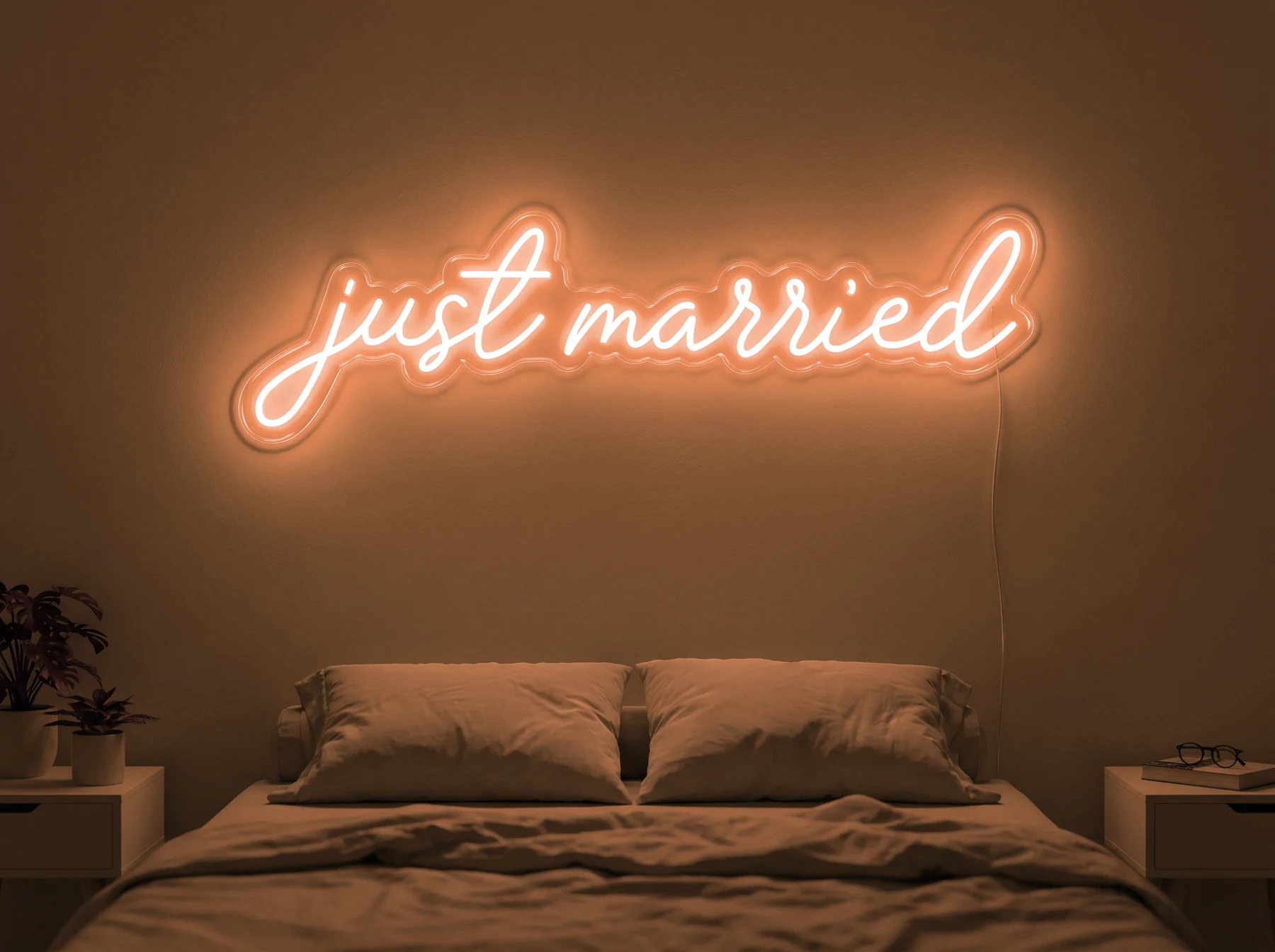 Neonskylt «Just Married» i orange LED-neon, monterad på vägg