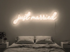 Neonskylt «Just Married» i varmvit LED-neon, monterad på vägg