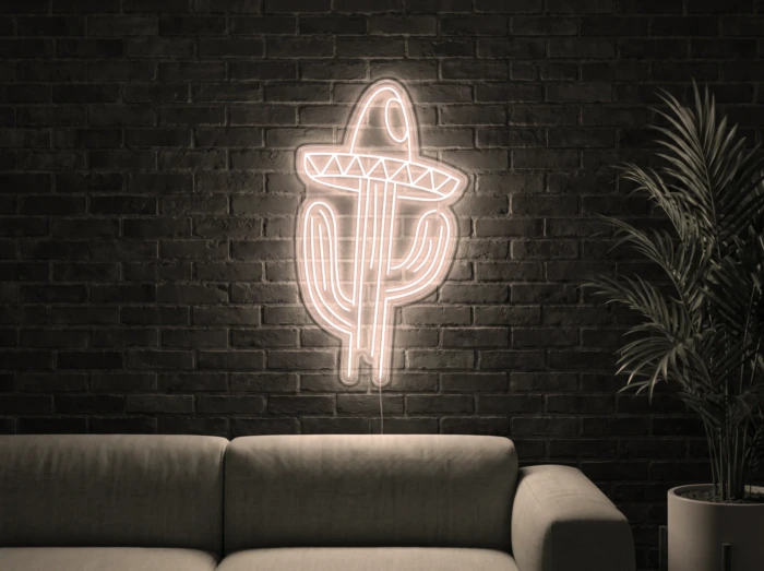 Neonskylt «Kaktus med hatt» i varmvit LED-neon, monterad på vägg