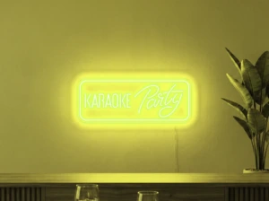Neonskylt «Karaoke Party» i gul LED-neon, monterad på vägg