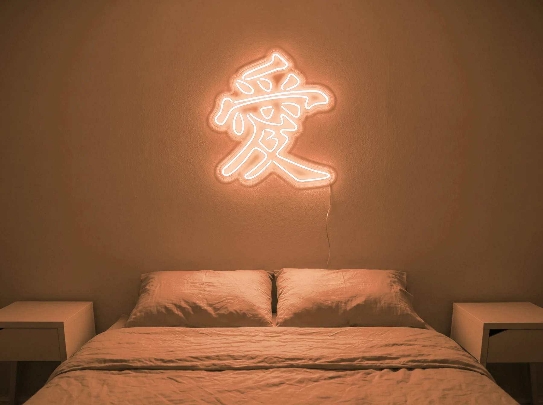 Neonskylt «Kärlek på kinesiska» i orange LED-neon, monterad på vägg