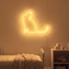 Neonskylt «Katt» i orange LED-neon, monterad på vägg