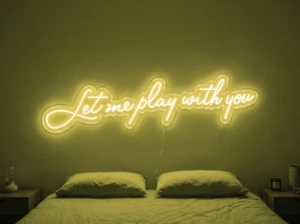 Neonskylt «Let Me Play With You» i gul LED-neon, monterad på vägg