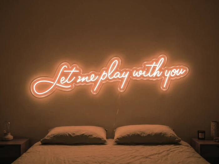 Neonskylt «Let Me Play With You» i orange LED-neon, monterad på vägg