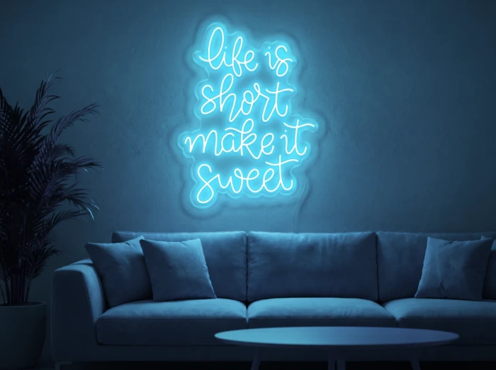 Neonskylt «Life Is Short» i isblå LED-neon, monterad på vägg