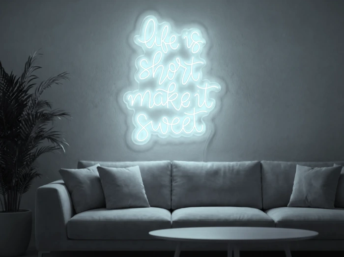 Neonskylt «Life Is Short» i iskall vit LED-neon, monterad på vägg