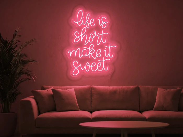 Neonskylt «Life Is Short» i röd LED-neon, monterad på vägg