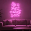 Neonskylt «Life Is Short» i rosa LED-neon, monterad på vägg