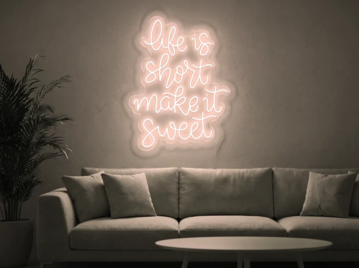 Neonskylt «Life Is Short» i varmvit LED-neon, monterad på vägg
