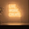 Neonskylt «Live Work Create» i orange LED-neon, monterad på vägg