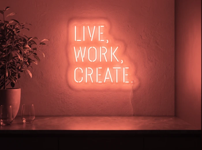 Neonskylt «Live Work Create» i röd LED-neon, monterad på vägg