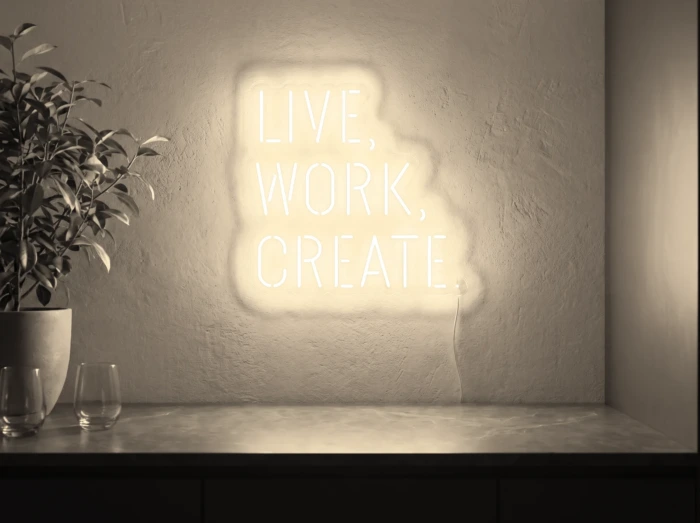 Neonskylt «Live Work Create» i varmvit LED-neon, monterad på vägg
