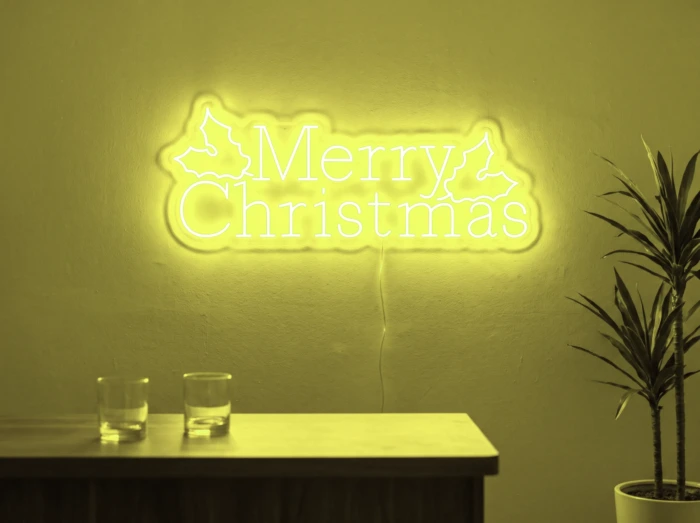 Neonskylt «Merry Christmas» i gul LED-neon, monterad på vägg