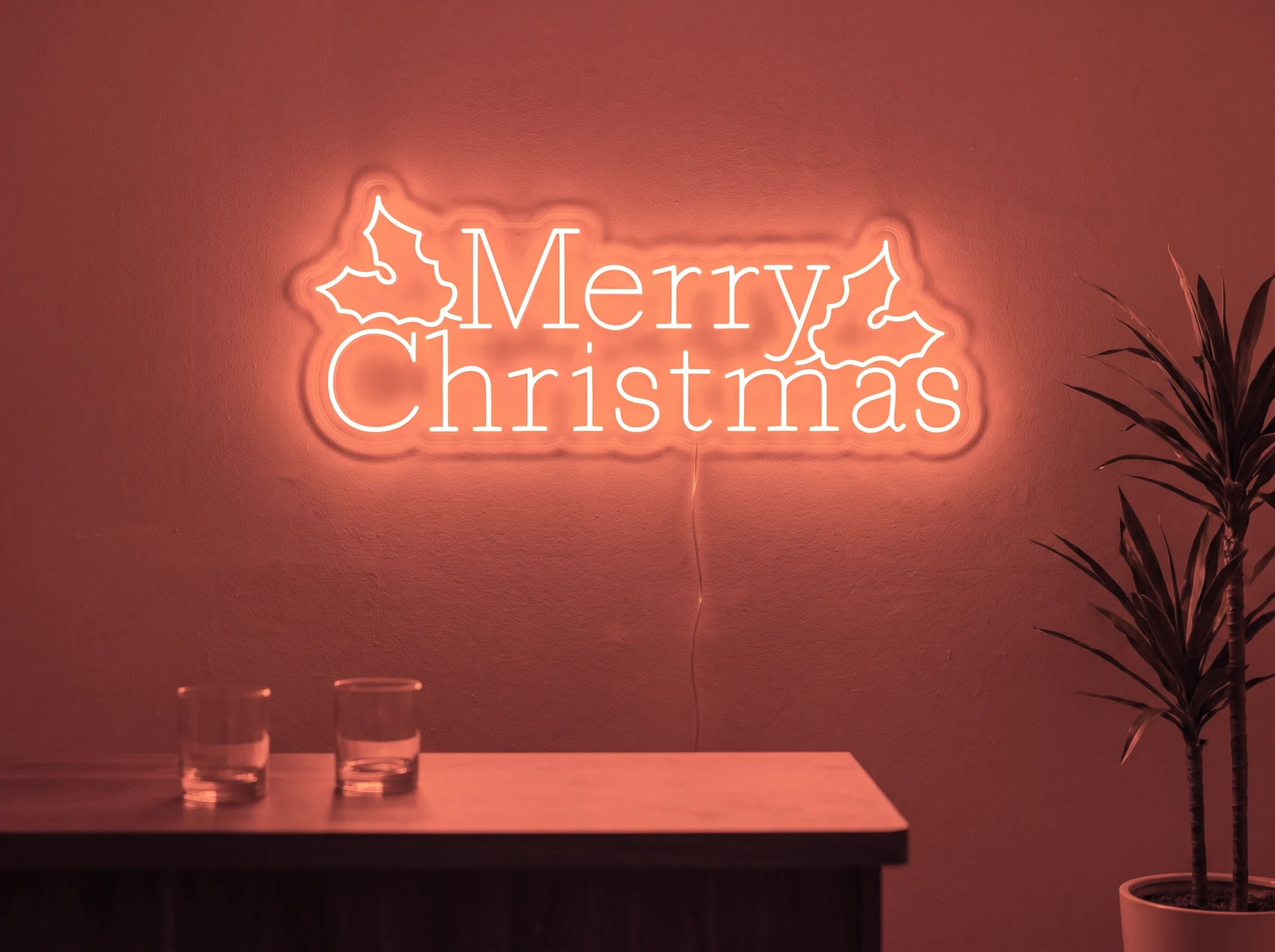 Neonskylt «Merry Christmas» i röd LED-neon, monterad på vägg