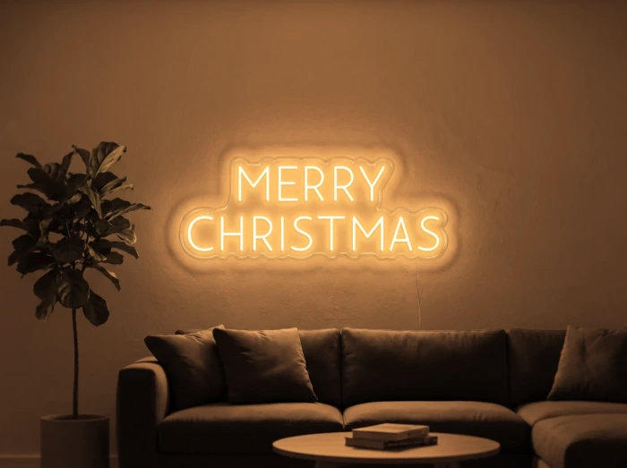 Neonskylt «Merry Christmas, versaler» i orange LED-neon, monterad på vägg