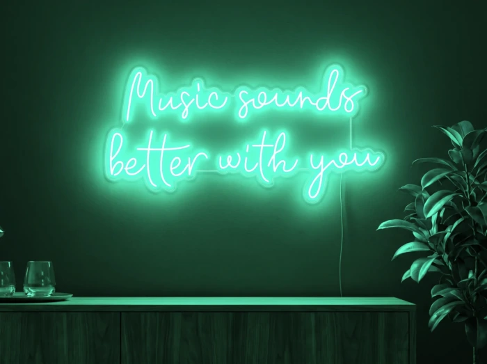 Neonskylt «Music Sounds Better With You» i mintgrön LED-neon, monterad på vägg