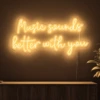 Neonskylt «Music Sounds Better With You» i orange LED-neon, monterad på vägg