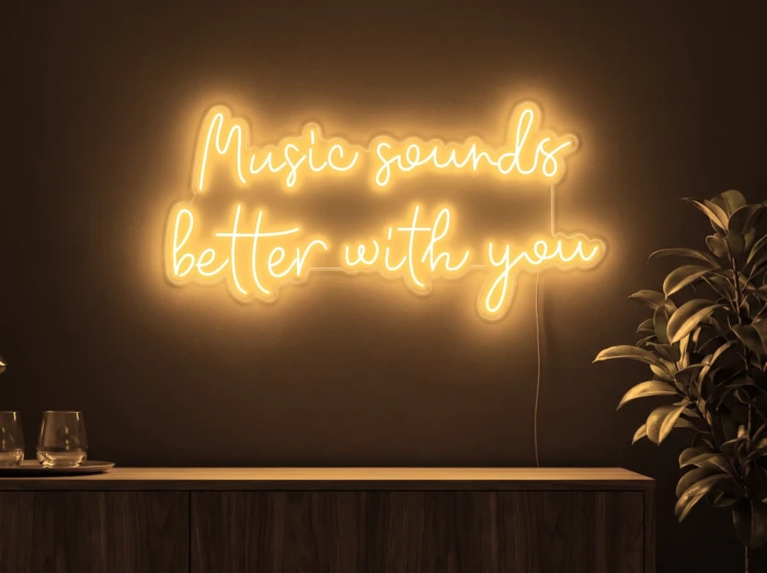 Neonskylt «Music Sounds Better With You» i orange LED-neon, monterad på vägg