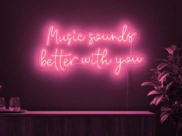 Neonskylt «Music Sounds Better With You» i rosa LED-neon, monterad på vägg