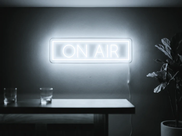 Neonskylt «On Air» i iskall vit LED-neon, monterad på vägg