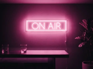 Neonskylt «On Air» i rosa LED-neon, monterad på vägg