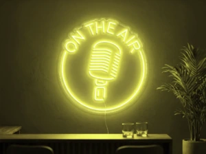 Neonskylt «On The Air» i gul LED-neon, monterad på vägg