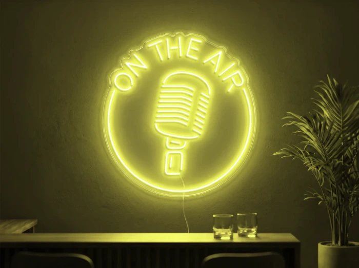 Neonskylt «On The Air» i gul LED-neon, monterad på vägg