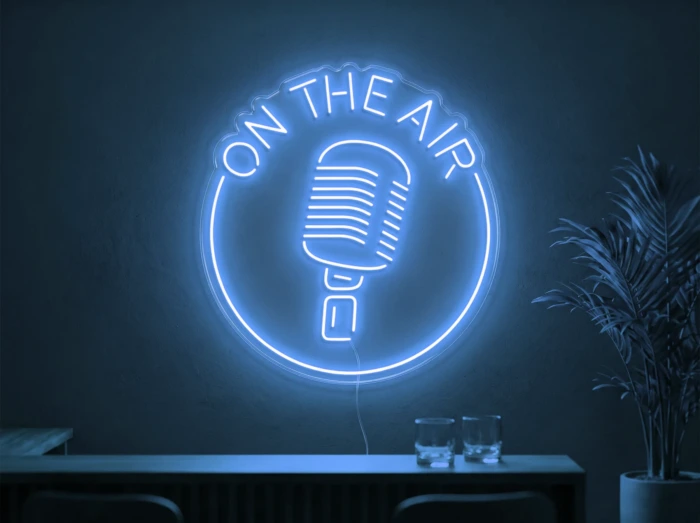 Neonskylt «On The Air» i isblå LED-neon, monterad på vägg