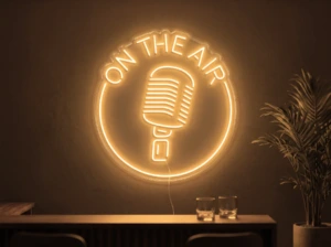 Neonskylt «On The Air» i orange LED-neon, monterad på vägg