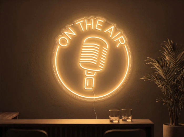 Neonskylt «On The Air» i orange LED-neon, monterad på vägg